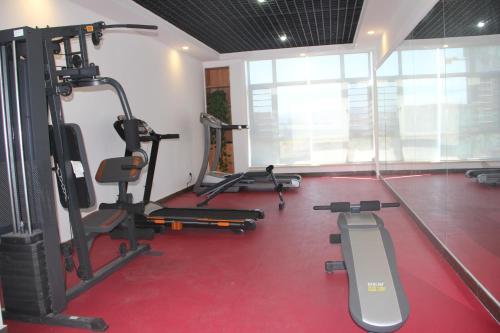 a gym with several tread machines in a room at James Joyce Hotel Qinhuangdao Railway Station in Qinhuangdao