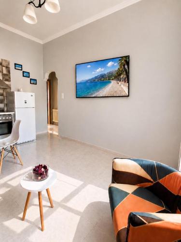 a living room with a couch and a tv on a wall at Petit house Vrachati in Vrachati