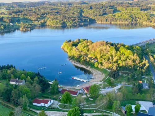 an aerial view of a lake with trees and houses at Chalets au bord du lac de Lavalette in Lapte
