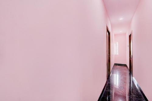 an empty hallway with a long floor and white walls at Hotel O KSR GRAND in Maula Ali