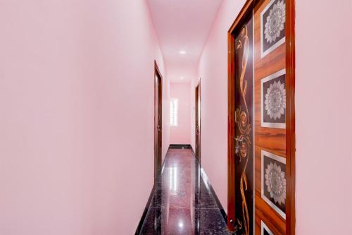 a long hallway with a wooden floor and white walls at Hotel O KSR GRAND in Maula Ali