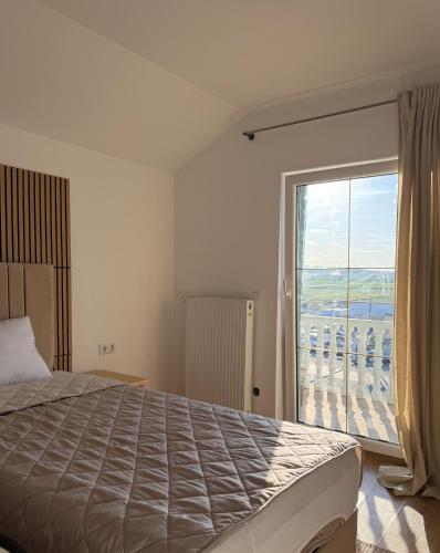 a bedroom with a bed and a large window at URBAN House Vienna in Gerasdorf bei Wien