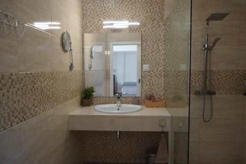 a bathroom with a sink and a shower and a mirror at Estudio Robusto in Monte do Valão
