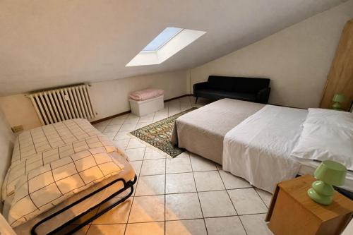 a bedroom with a bed and a chair and a window at Casa LOUES in Asti