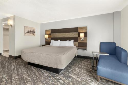 a hotel room with a bed and a blue chair at Best Western Plus Wausau Tower Inn in Wausau