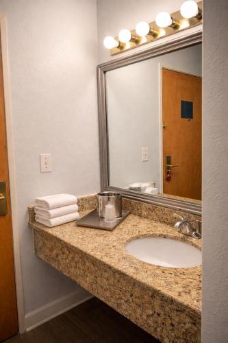 a bathroom with a sink and a mirror at Americas Best Value Inn Raleigh in Raleigh