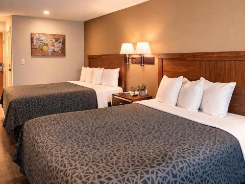 a hotel room with two beds in a room at Americas Best Value Inn Raleigh in Raleigh