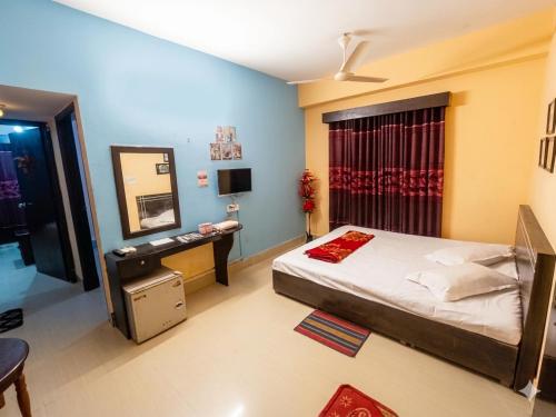 a bedroom with a bed and a desk and a mirror at Epindi Studio Apartment in Cox's Bazar