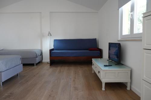 a living room with a blue couch and a table at Estudio Robusto in Monte do Valão