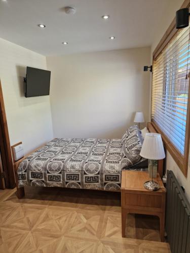 a bedroom with a bed and a table with a lamp at Nivahana in Edinburgh