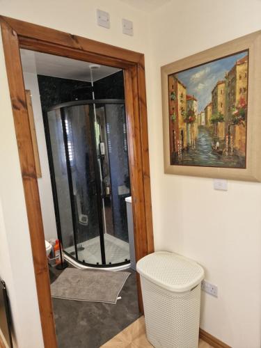 a bathroom with a glass door and a mirror at Nivahana in Edinburgh