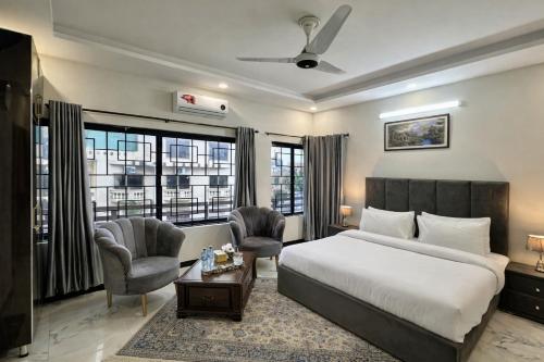 a hotel room with a bed and two chairs at Comfort Family Lodges Islamabad in Islamabad