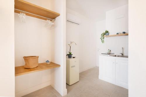a kitchen with white cabinets and a refrigerator at Enea Dimora Procida in Procida