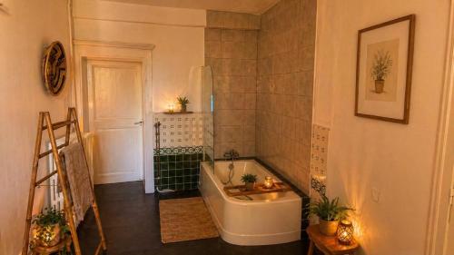 a bathroom with a bath tub and a sink at Les jardins d'Elise in Lure