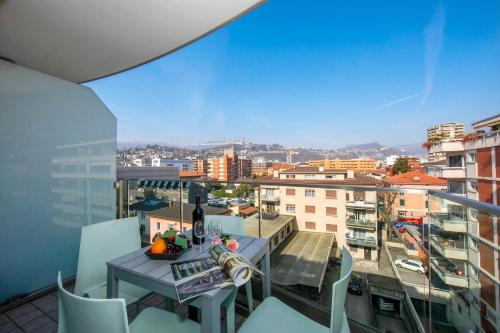 a table and chairs on a balcony with a view of a city at Via al Chioso in Lugano