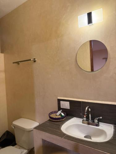 a bathroom with a sink and a toilet and a mirror at Casa Faustos in Mérida