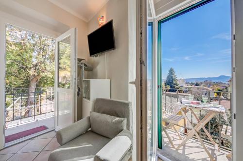 a living room with a couch and a balcony at Nido Belvedere AC and Lake View - Happy Rentals in Lesa