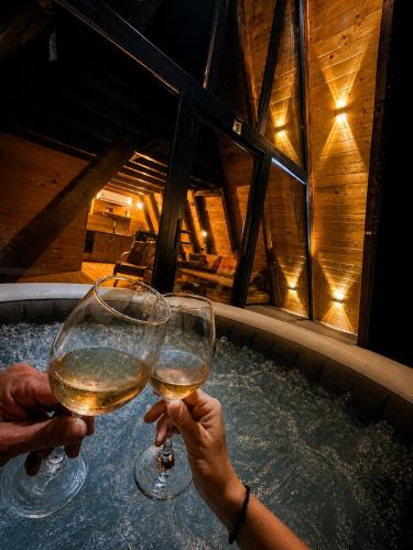two people holding glasses of wine in a hot tub at Krushevski Konaci 1 in Kruševo