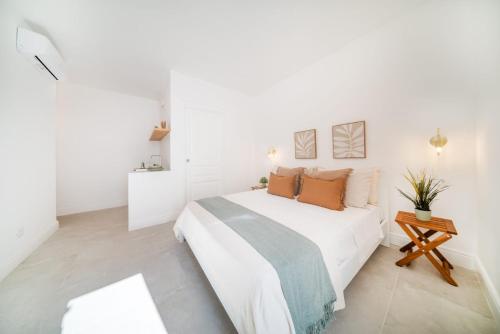 a white bedroom with a bed and a table at Enea Dimora Procida in Procida