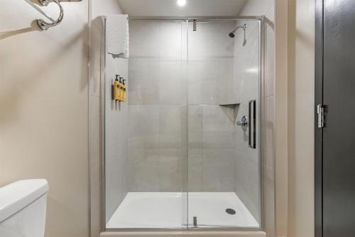 a shower with a glass door in a bathroom at Best Western Plus Neepawa Hotel in Neepawa