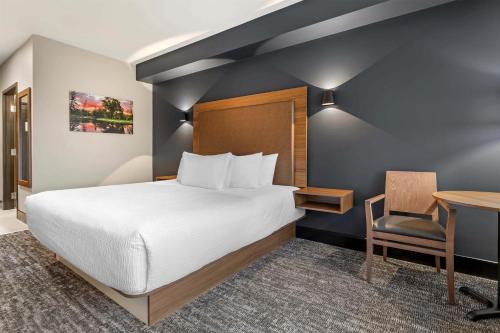a hotel room with a bed and a desk at Best Western Plus Neepawa Hotel in Neepawa