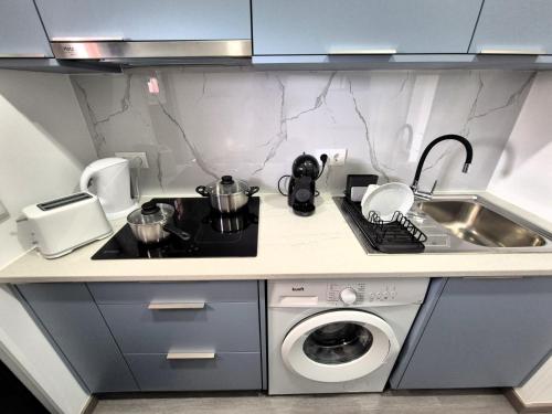 a kitchen with a sink and a washing machine at Cimo das Dutras in Horta