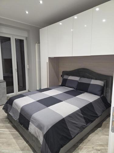 a bedroom with a black and white bed with white cabinets at Living Monza Arengario in Monza