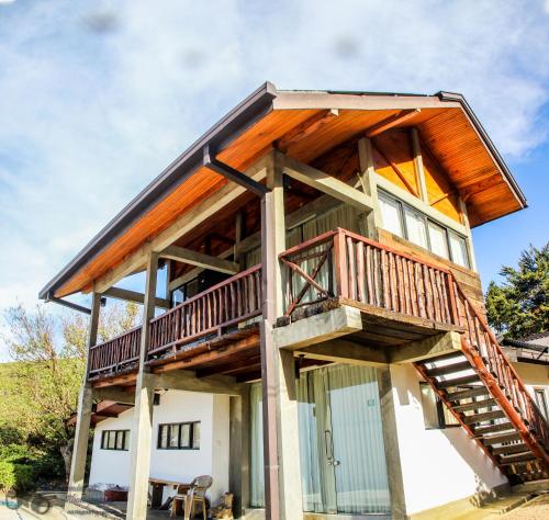 a timber frame house with a wrap around deck at Hill Safari - Tea Estate Villa in Ohiya