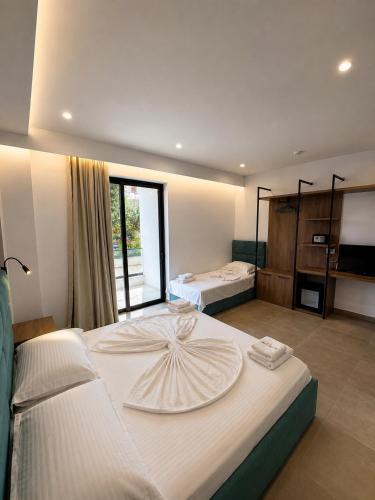 a large bedroom with two beds and a window at Prestige Hotel in Ksamil