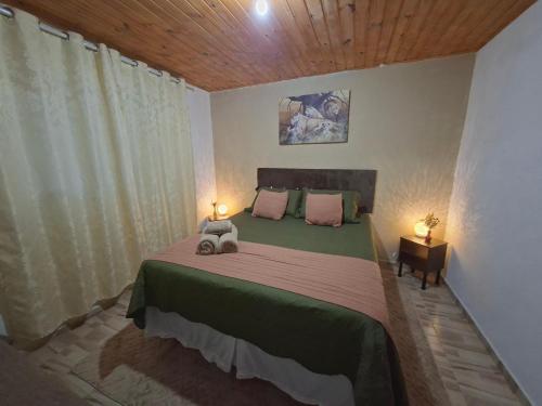 a bedroom with a large bed with two lamps on it at Sítio jaguary in Camanducaia