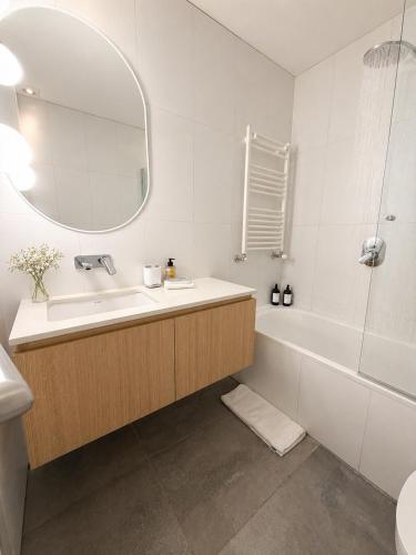 a bathroom with a sink and a tub and a mirror at B612 Bariloche in San Carlos de Bariloche