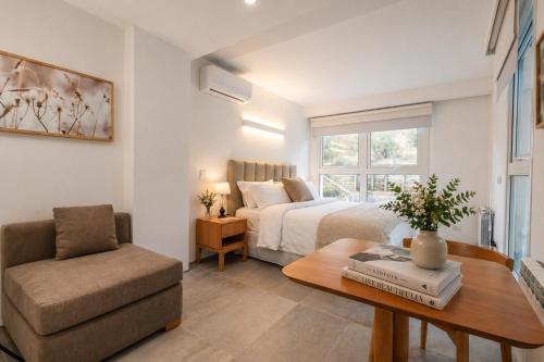 a bedroom with a bed and a chair and a table at B612 Bariloche in San Carlos de Bariloche
