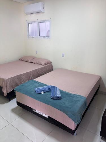 two beds sitting next to each other in a room at Vista Bela Guesthouse in Barra do Garças