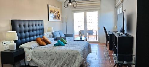 a bedroom with a bed with stuffed animals on it at Rooms Flor del Pato in Benalmádena