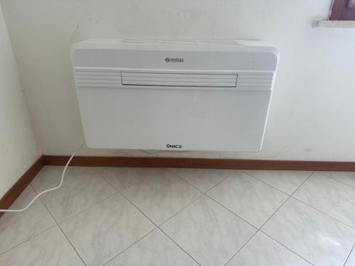 a white dishwasher in a corner of a room at La Casina in Cecina