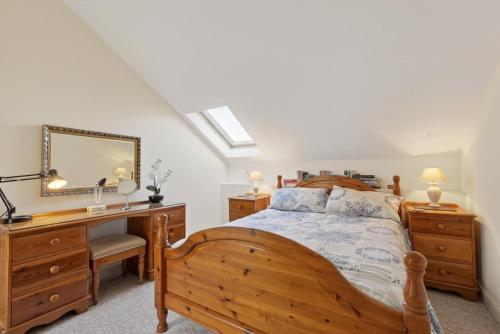 a bedroom with a wooden bed with a desk and a mirror at 2 Bed in Beaminster oc-63047 in Broadwindsor