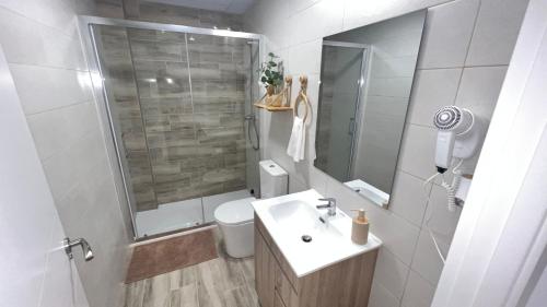 a bathroom with a sink and a shower and a toilet at Villamadrid Home 2 in Madrid