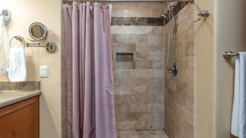 a bathroom with a shower with a pink shower curtain at Las Palomas Beach & Golf Resort - One Bedroom Condos in Puerto Peñasco
