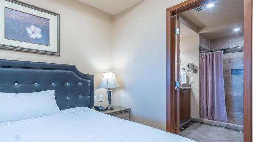 a bedroom with a large bed and a shower at Las Palomas Beach & Golf Resort - One Bedroom Condos in Puerto Peñasco