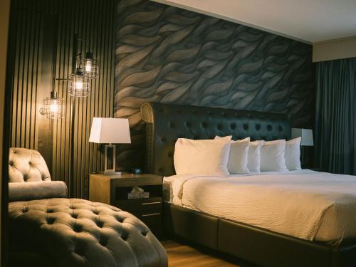 a bedroom with a bed with a stone wall at The Thompson Hotel in Kamloops