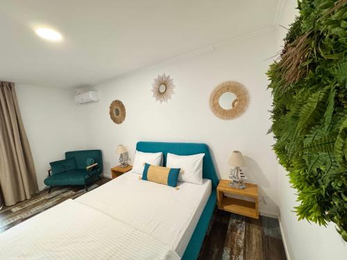 a bedroom with a bed and a green chair at Delta Land Bungalows in Crisan