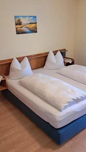 a bedroom with two beds with white sheets at Bergbauern Wirtshaus in Kötschach