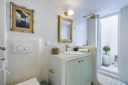 a bathroom with a sink and a mirror at Manu's House - Refined Design, Effortless Space in Skopelos Town