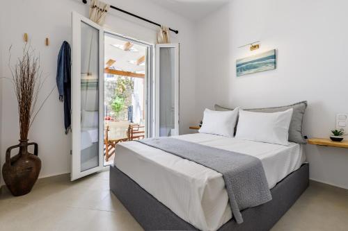 a bedroom with a bed and a large window at Manu's House - Refined Design, Effortless Space in Skopelos Town