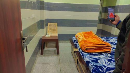 a person taking a picture of a room with a bed and a chair at Soni Hotel in Hanumāngarh