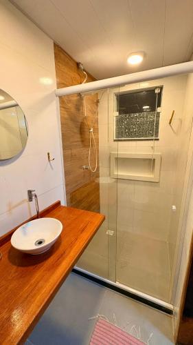 a bathroom with a glass shower and a sink at Loft Brisa de Búzios in Búzios