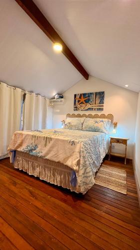 a bedroom with a bed and a wooden floor at Loft Brisa de Búzios in Búzios