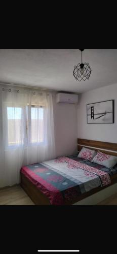 a bedroom with a bed and a window at Talic Apartmani in Sutomore