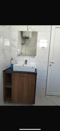 a bathroom with a white sink and a mirror at Talic Apartmani in Sutomore