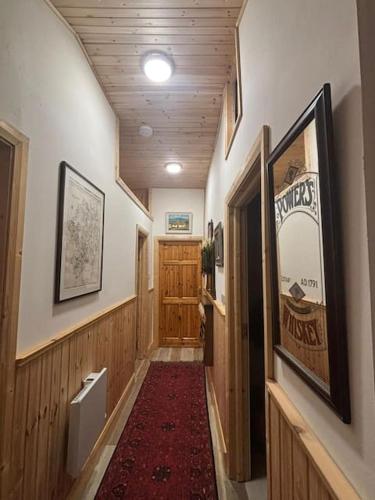 a hallway with a wooden door and a red carpet at Mag Byrne's Cottage in Sandy Ford